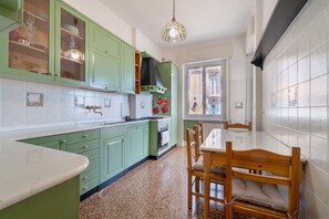 Una cucina con mobili verdi, un tavolo da pranzo in legno e una finestra con vista.