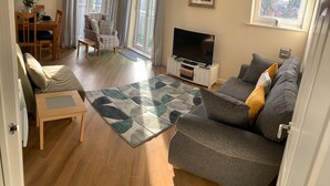 Un salon comprenant un canapé, un téléviseur, une table à manger et une chaise.