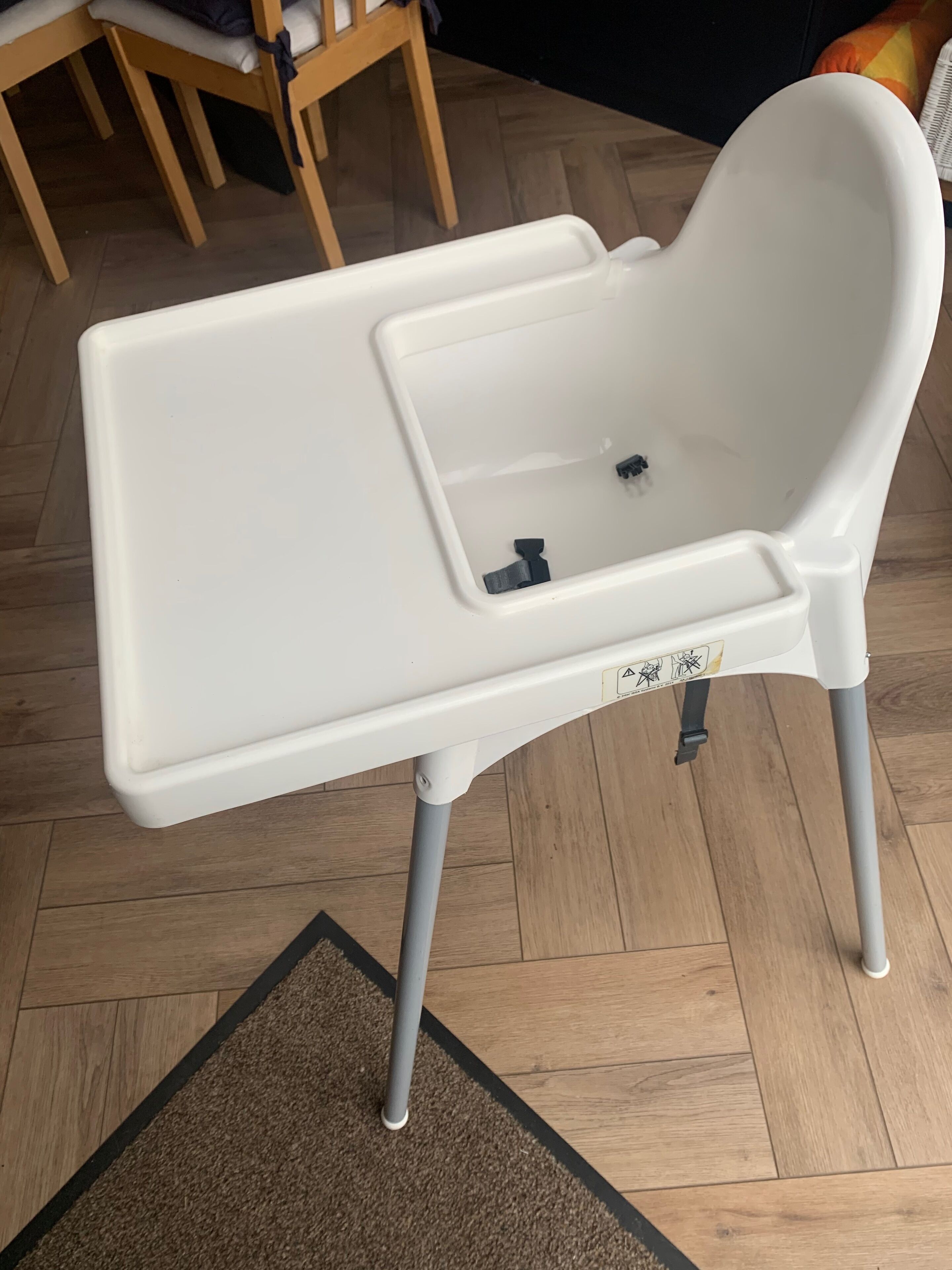 A white chair with a tray table and a footrest.