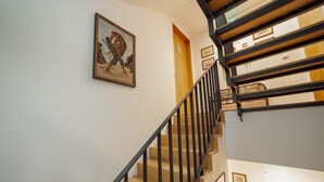 A staircase with wooden steps and black railings, a framed picture on the wall, and a door at the top. - Carmo Residence Porto - S ANA by Vacationy (Porto)