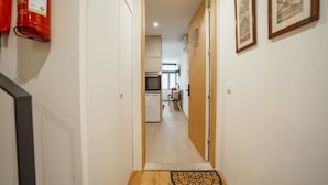 A hallway with a wooden door, a fire extinguisher, and framed pictures on the wall. - Carmo Residence Porto - S Helena by Vacationy (Porto)