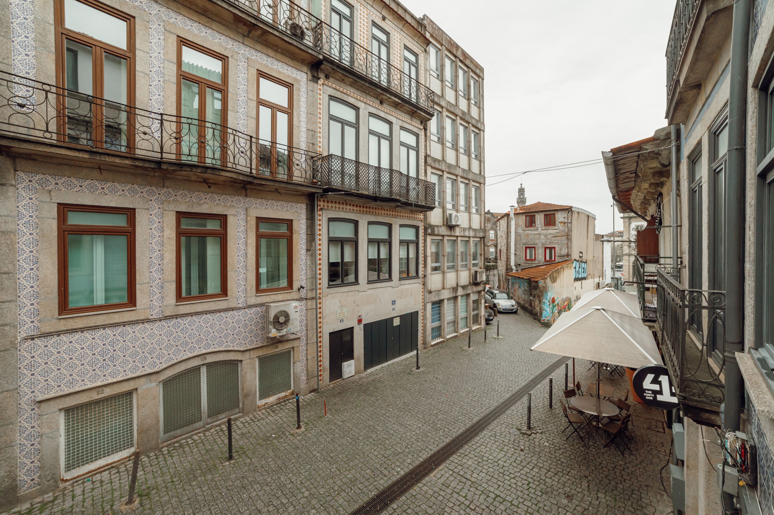 Una calle adoquinada con edificios que presentan fachadas de azulejos ornamentales y balcones.
