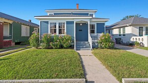 Une maison à deux étages avec un porche à l’avant, le numéro « 4014 » inscrit sur le côté et une pelouse bien entretenue.