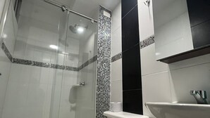 Une salle de bain moderne avec une douche à parois de verre, des toilettes et un lavabo.
