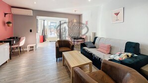 Un salon moderne comprenant un canapé, des fauteuils, une table basse et un coin repas avec une table et des chaises.