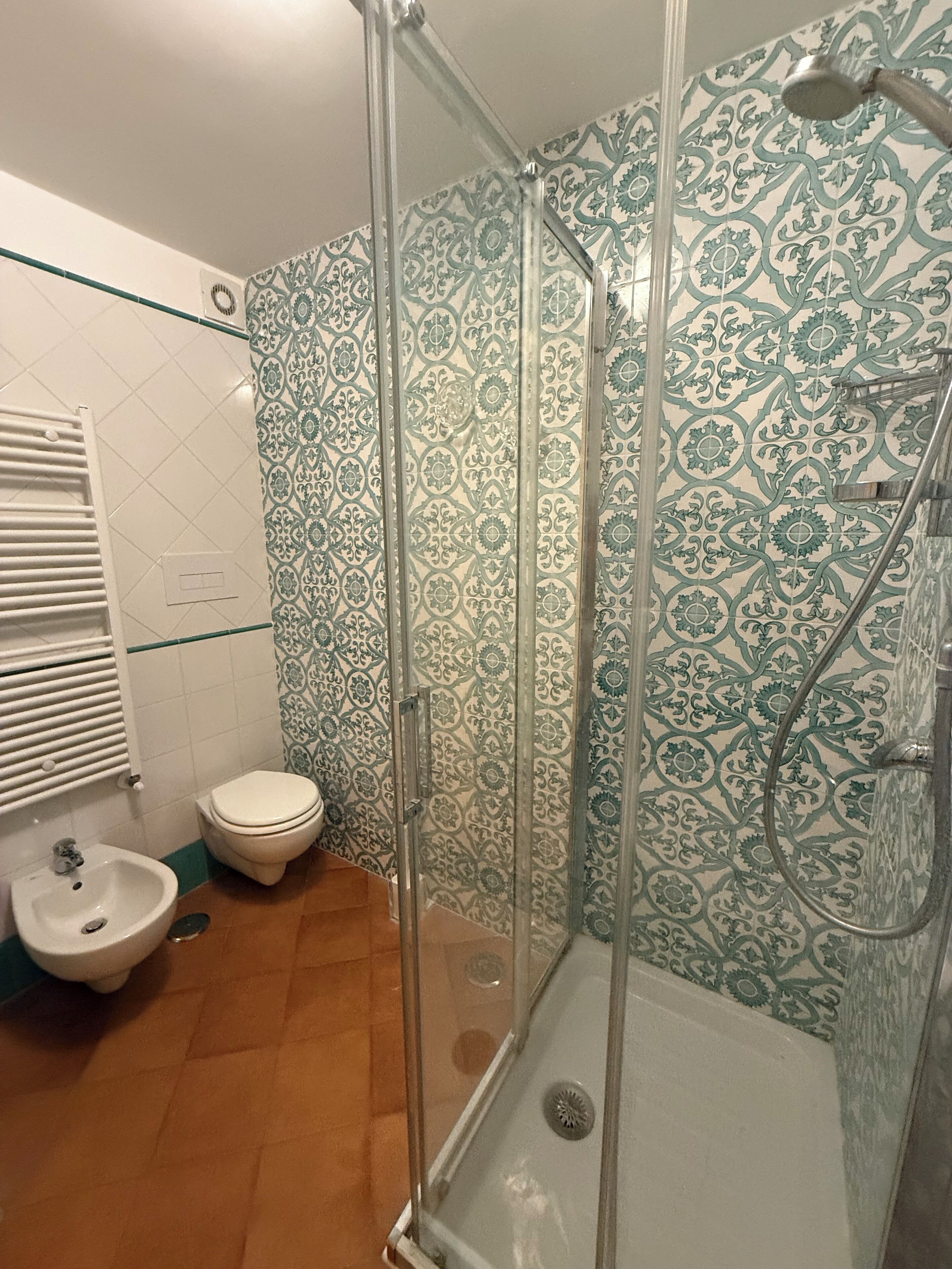 Une salle de bain avec douche, toilettes et lavabo.