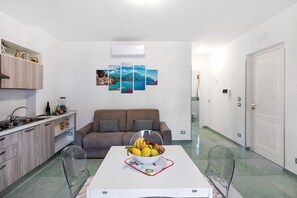 Une cuisine moderne avec une table à manger, un canapé et une chaise en verre transparent.