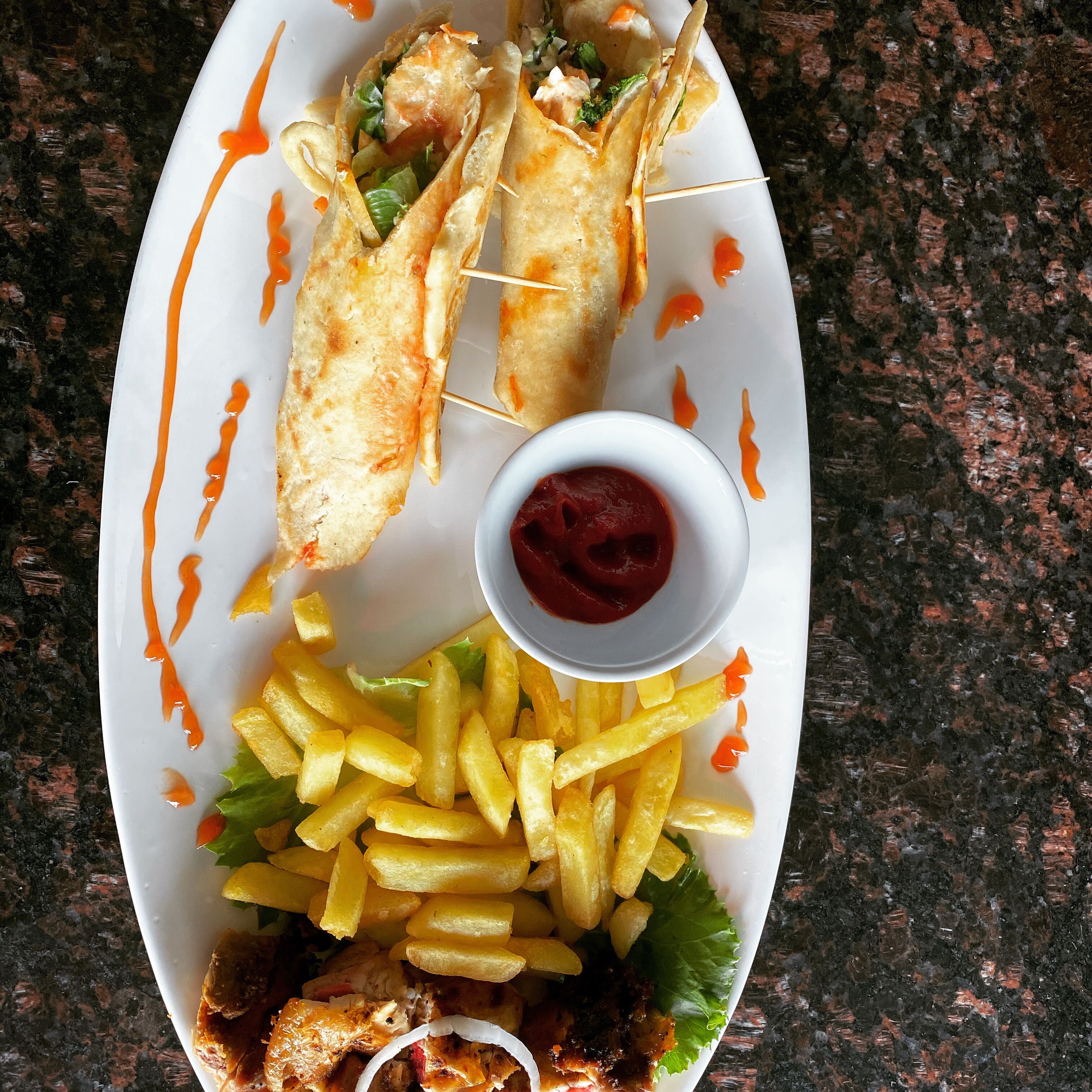 A plate with fish sticks, fries, and a small bowl of ketchup.
