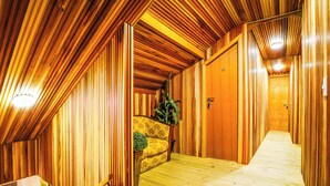 A wooden interior hallway with a bench and a potted plant. - VELINN Pousada Villa Paty II (Campos do Jordão)