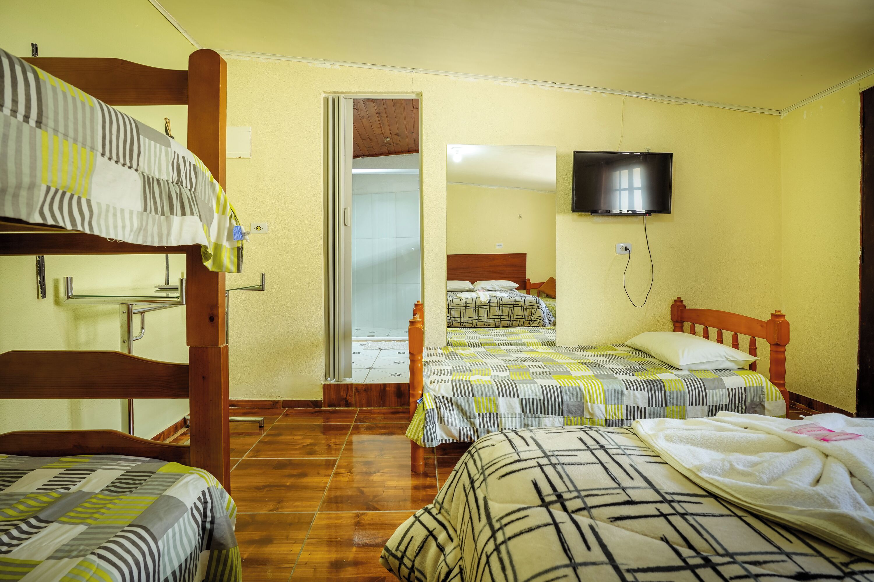 A room with two beds, a television, and a wooden door.