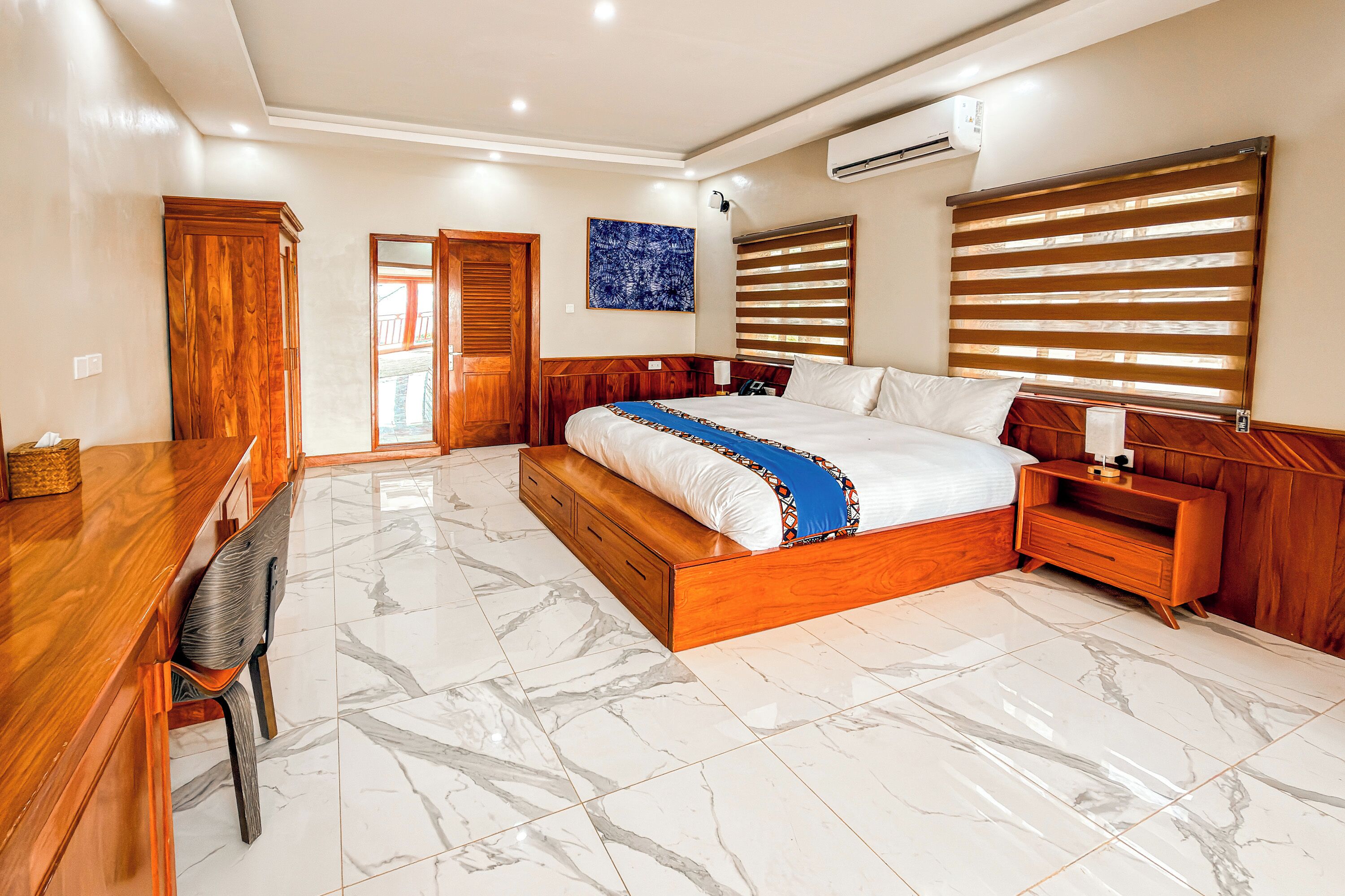 A bedroom with a wooden bed, a desk, and a chair.