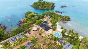 An aerial view of a coastal property with a beach, a small island, and a swimming pool. - Mozza Beach Resort (York)