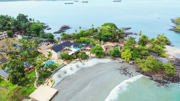 A coastal resort with beachfront villas, a swimming pool, and a rocky shoreline. - Mozza Beach Resort (York)