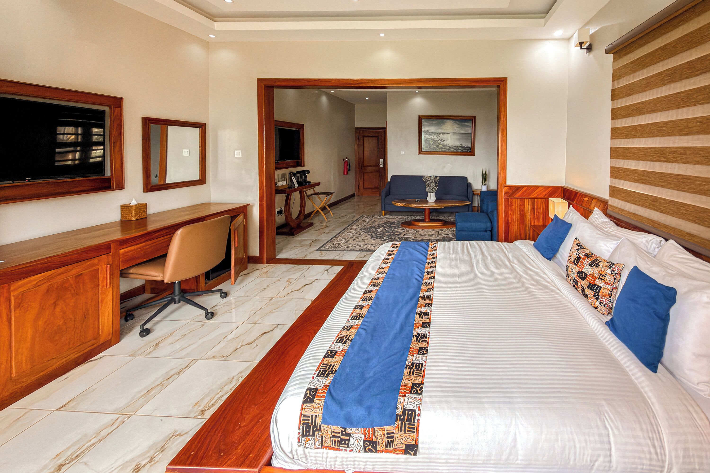 Une chambre d’hôtel équipée d’un lit, d’un bureau, d’une chaise, d’un canapé et d’une télévision.