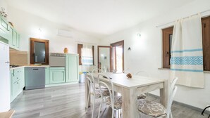 Una cocina con una mesa de comedor, sillas y un refrigerador.