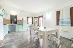 Una cocina con una mesa de comedor, sillas y un refrigerador.