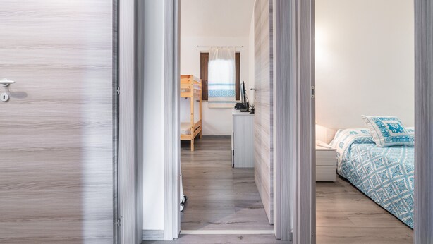Un dormitorio con cama, mesita de noche y escritorio con silla.