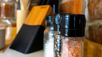 A kitchen counter with salt and pepper shakers, a wooden cutting board, and a knife block.