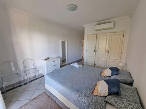 Une chambre à coucher avec un lit, une armoire, un bureau et une chaise.
