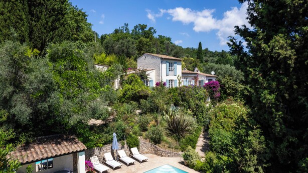 A villa with a swimming pool, surrounded by lush greenery and trees. - Beautiful ground floor apartment in villa in Opio. (Opio)