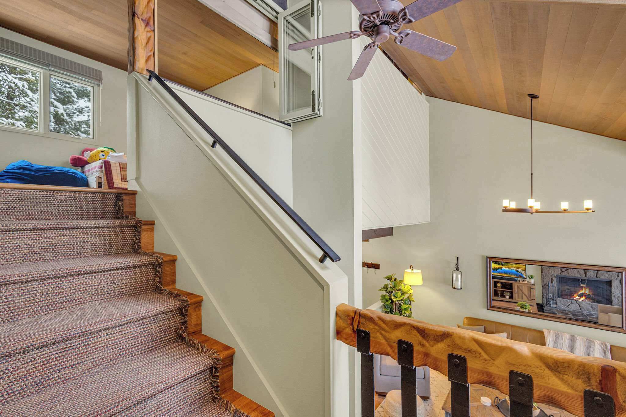 A staircase with a wooden handrail and a ceiling fan.