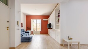 Un grand salon comprenant un canapé, un téléviseur et une petite table.