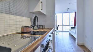 A modern kitchen with a stainless steel stove, a copper pot, and a black induction cooktop. - Upperton Road Studios in Leicester (Leicester)