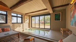 Un vaste espace de vie avec une grande fenêtre, une piscine et un coin salon confortable.