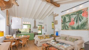 Una sala de estar acogedora con comedor, cocina y un amplio ventanal.