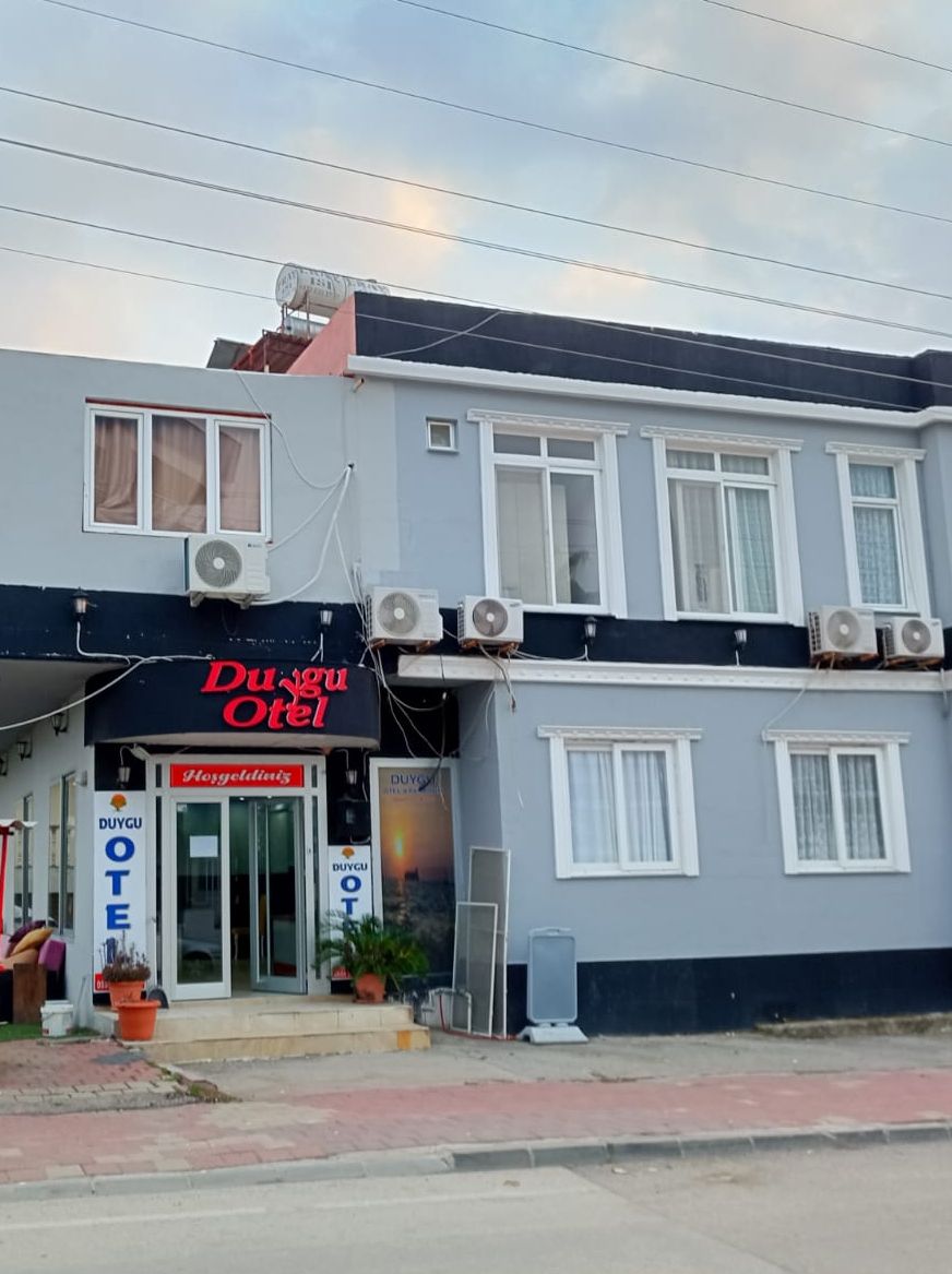 Ein Gebäude mit einem Schild, auf dem "Duygu OTE" steht, und mehreren Klimaanlagen.