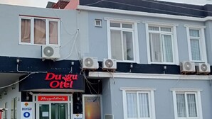 A building with a sign reading "Duygu OTE" and multiple air conditioning units.