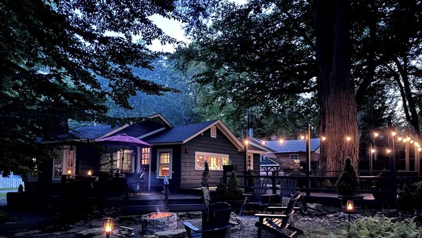 A cabin with a fire pit, outdoor seating, and string lights. - Enchanted Fox Dell Cottage (Smallwood)