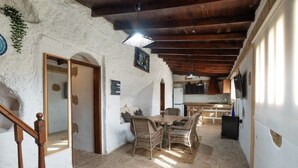 A rustic interior with a dining area, wooden staircase, and a kitchen. - Vacation Home 'Añaterve' with Sea View, Private Pool and Wi-Fi (Arico)