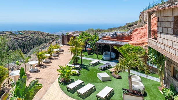 Terraza en la azotea con mobiliario exterior y vista al océano.