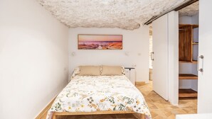 Un dormitorio con una cama, un cuadro y vistas de una escalera de madera.