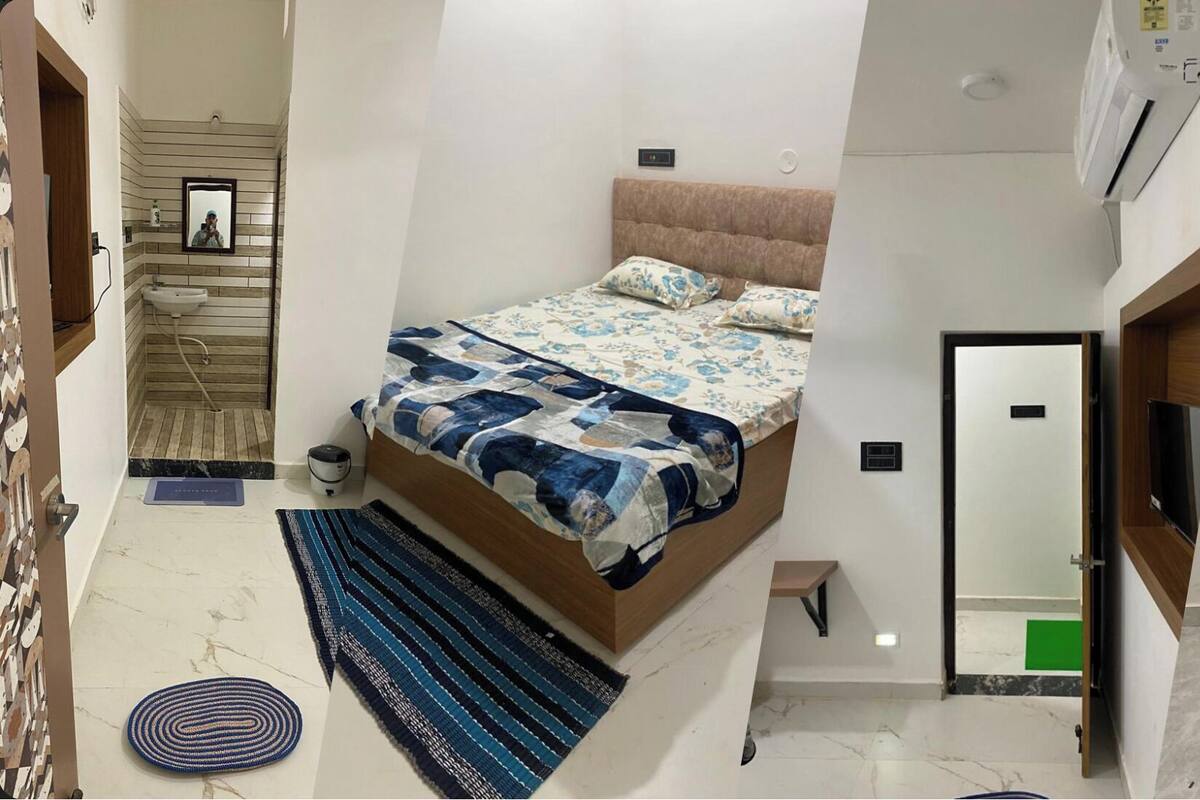 A compact bedroom with a bed, a TV, and a wardrobe.