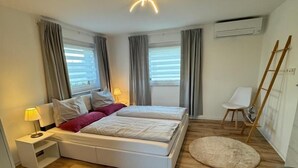 Un dormitorio con una cama, mesitas de noche, un escritorio y una silla.