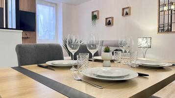 A dining area with a wooden table set for four, including plates, glasses, and cutlery.