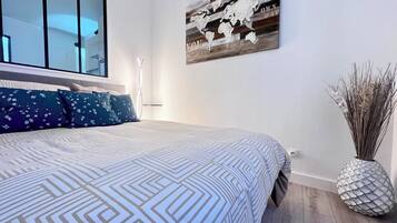 A bedroom with a large bed, a world map artwork, and a decorative vase.