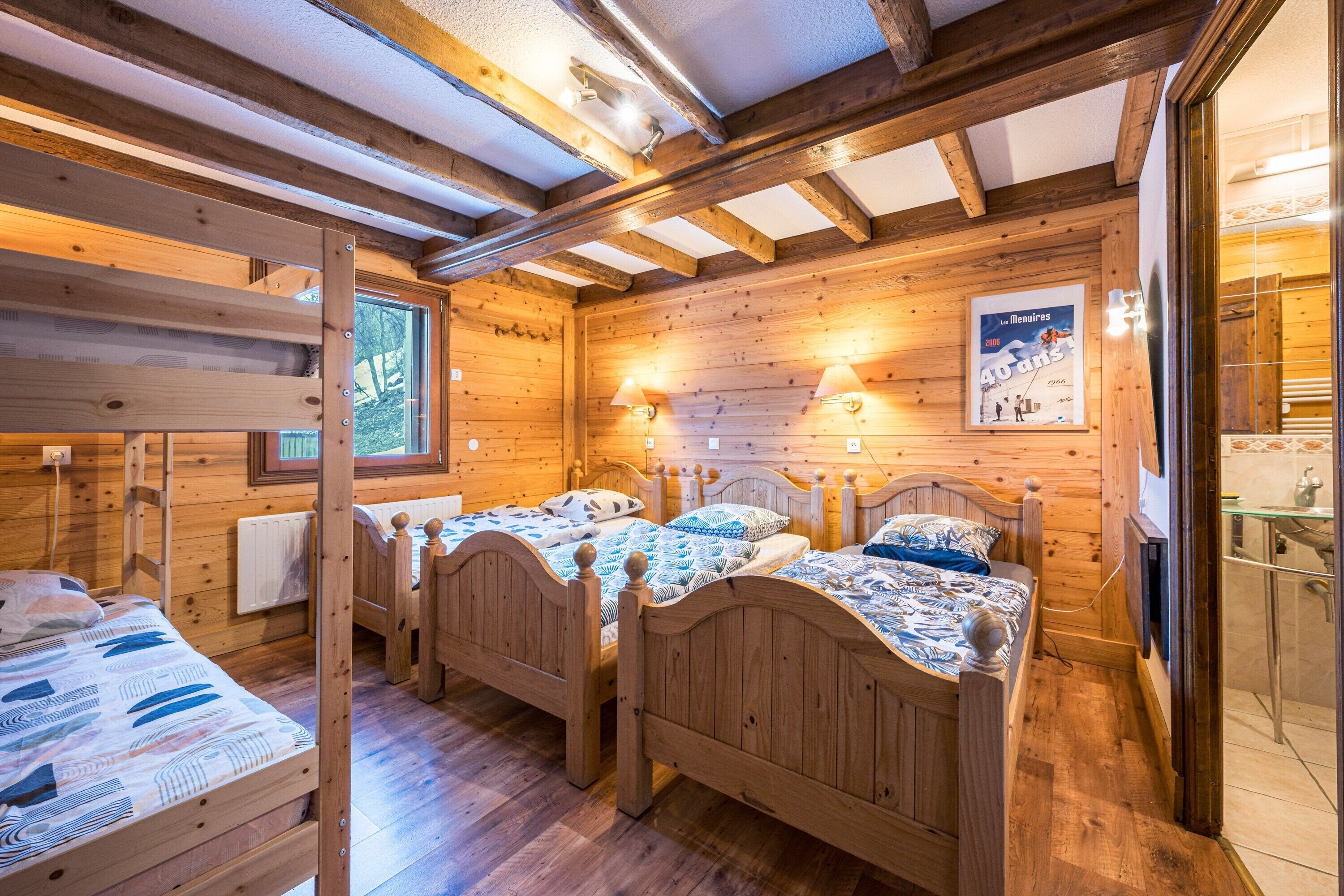 Une cabane en bois avec des lits superposés, un plafond en bois et une affiche accrochée au mur.