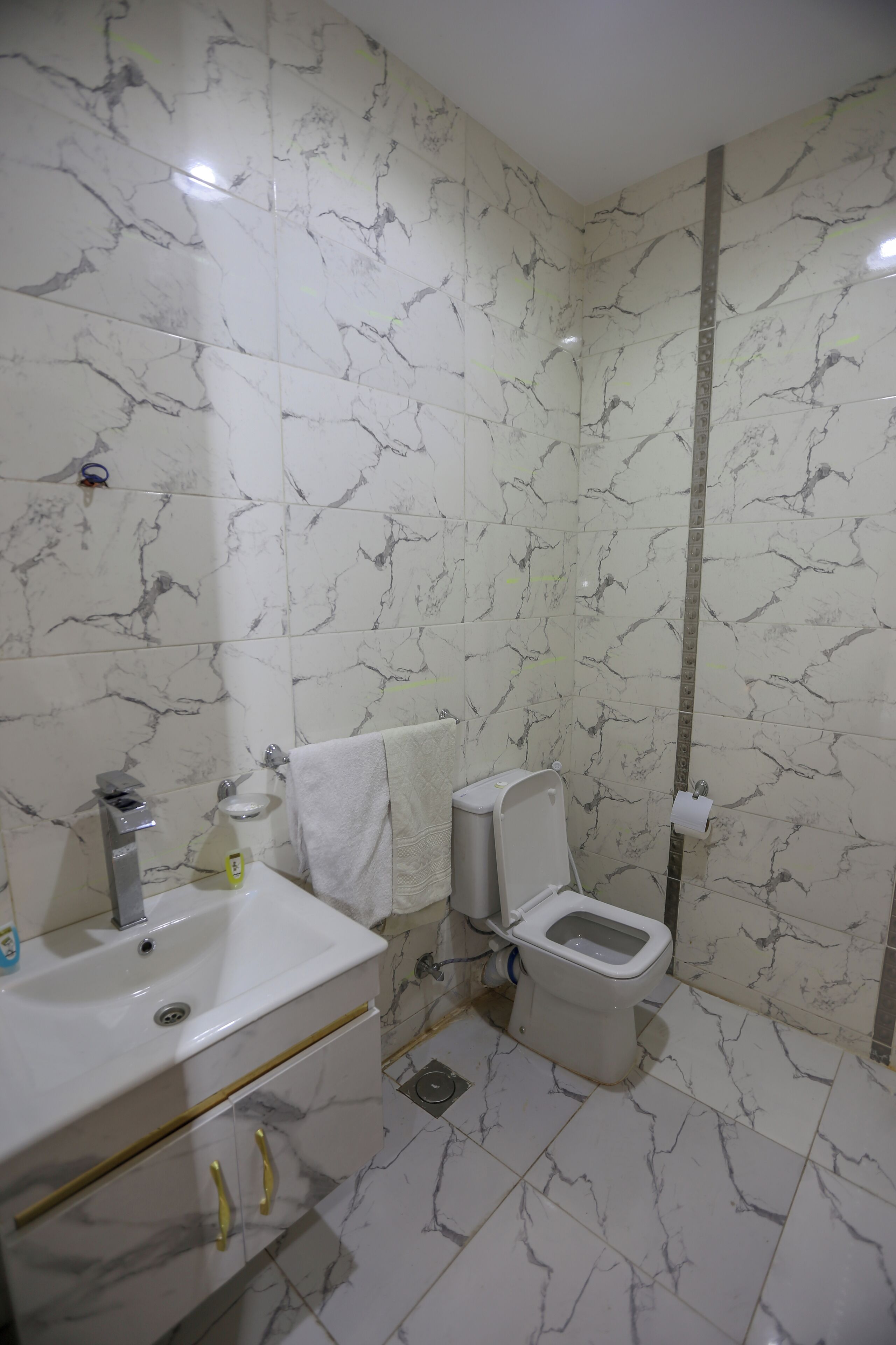 Un baño con inodoro, lavamanos y tocador.