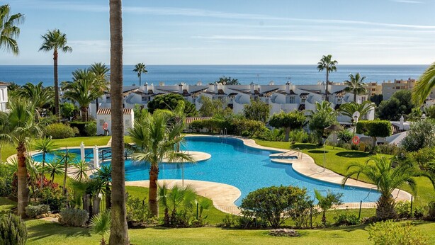 A resort with a large pool, palm trees, and ocean views. - Apartment 'Calahonda Park' with Sea View, Wi-Fi and Air Conditioning (Calahonda)