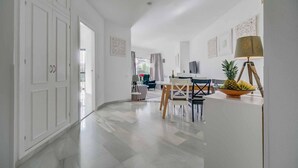A spacious living area with a dining table, chairs, and a TV mounted on the wall. - Apartment 'Calahonda Park' with Sea View, Wi-Fi and Air Conditioning (Calahonda)