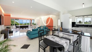 A modern living space with a dining area, kitchen, and seating area with a view.
