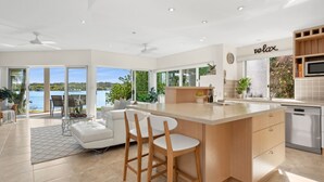 Cocina moderna con una isla grande, taburetes de bar y vista al lago.