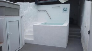 Ein helles Badezimmer mit einer Badewanne, einer Tür und einem Schild mit einem Namen.