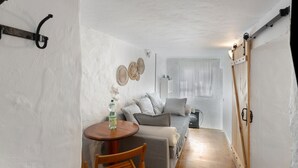 Ein kompakter Wohnbereich mit einer Couch, einem kleinen Tisch und einem Stuhl.