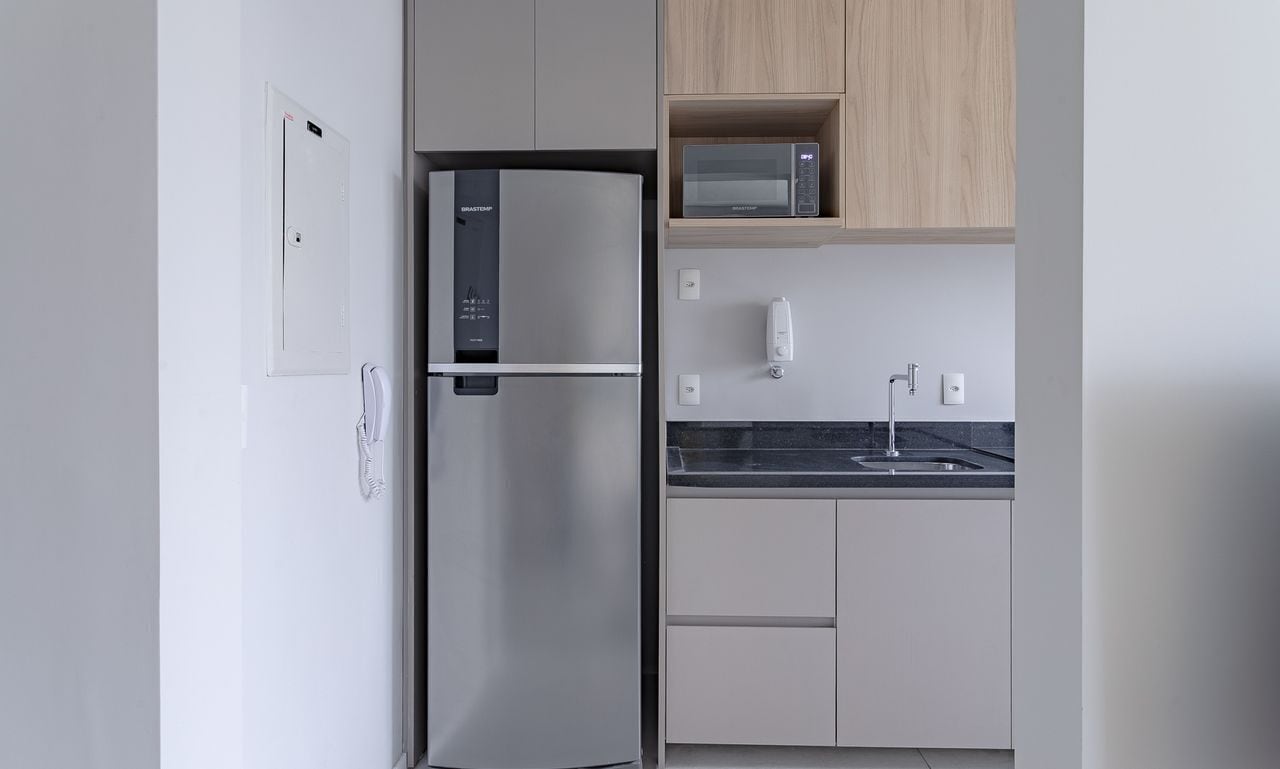 A modern kitchen with a built-in refrigerator, microwave, and sink.