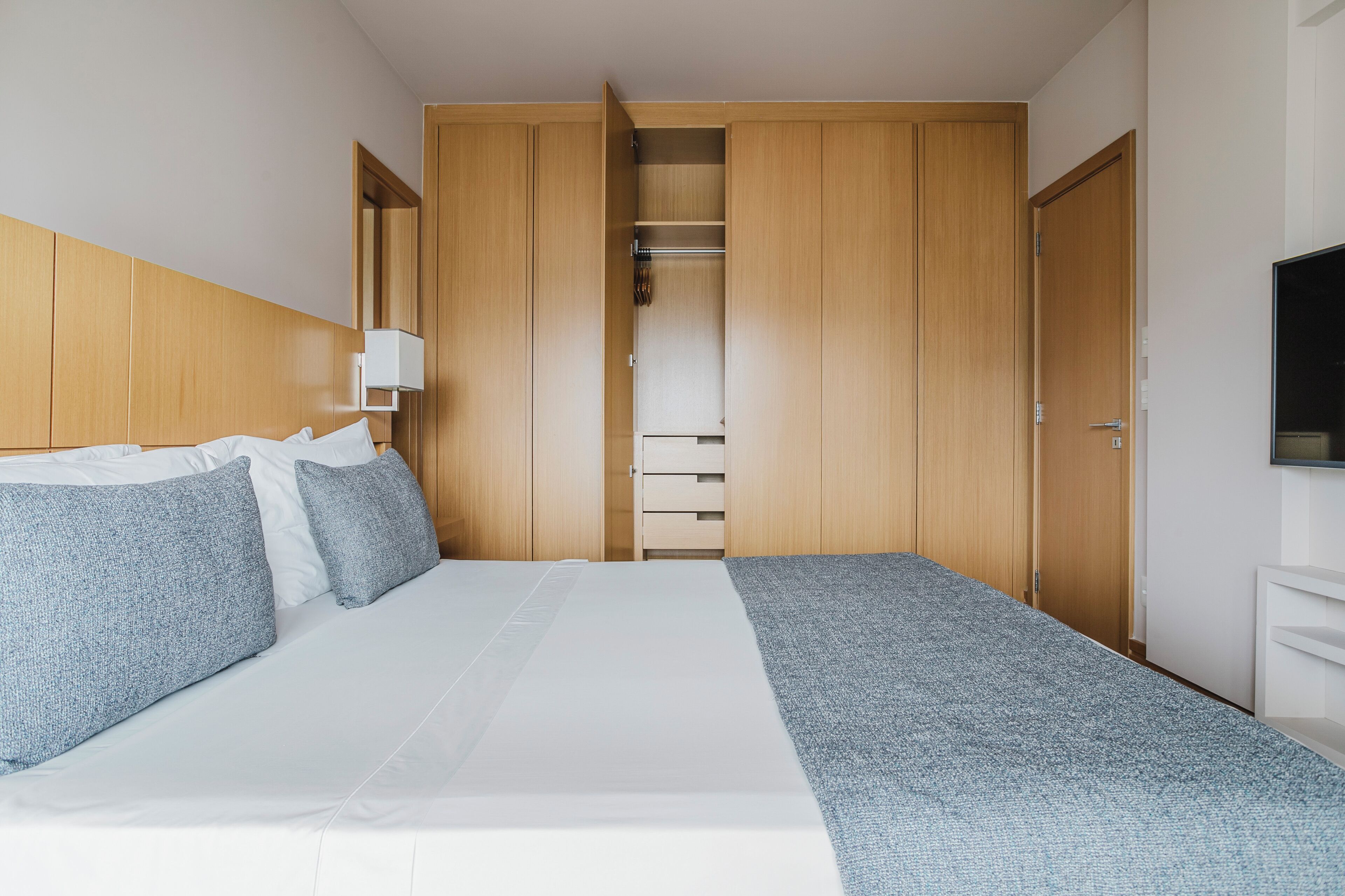 Une chambre d’hôtel avec un lit, une armoire et un téléviseur.