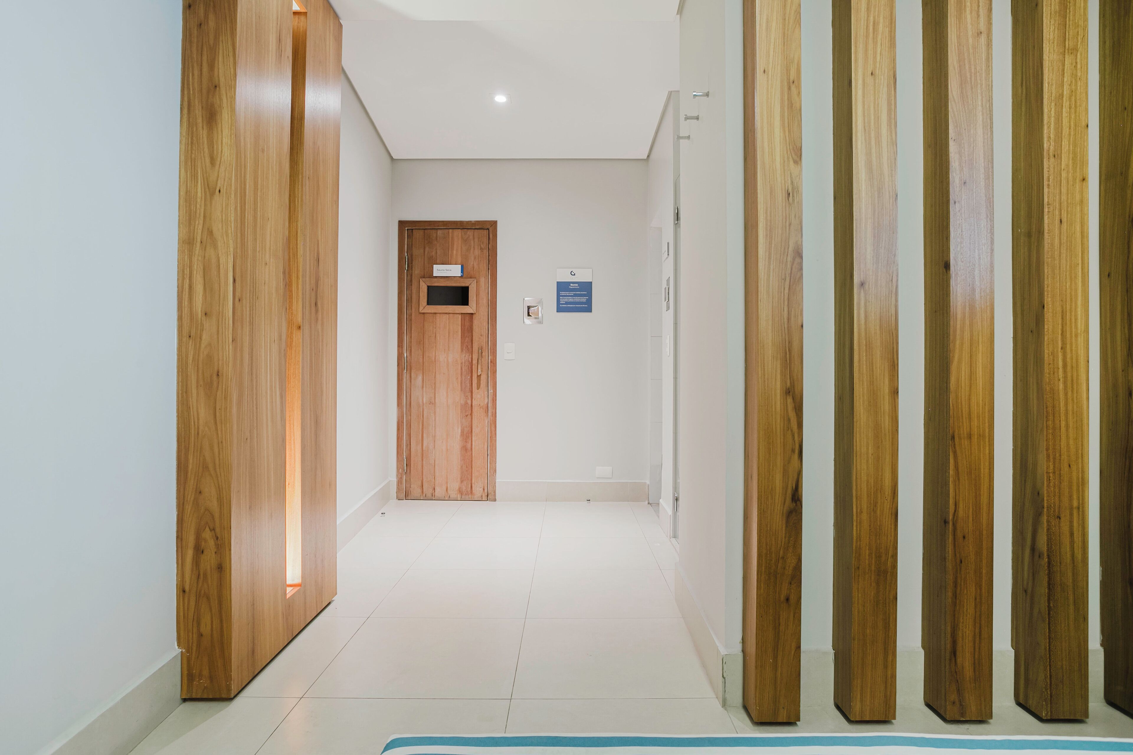 A hallway with wooden paneling on the walls and a wooden door at the end.